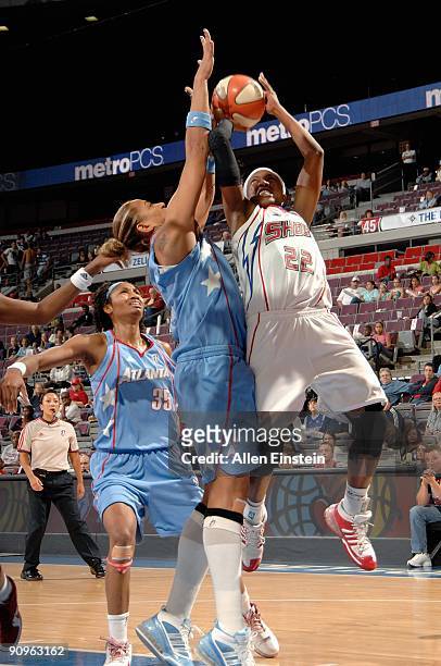 Alexis Hornbuckle of the Detroit Shock goes up for a shot against Erika de Souza and Angel McCoughtry of the Atlanta Dream in Game one of the Eastern...