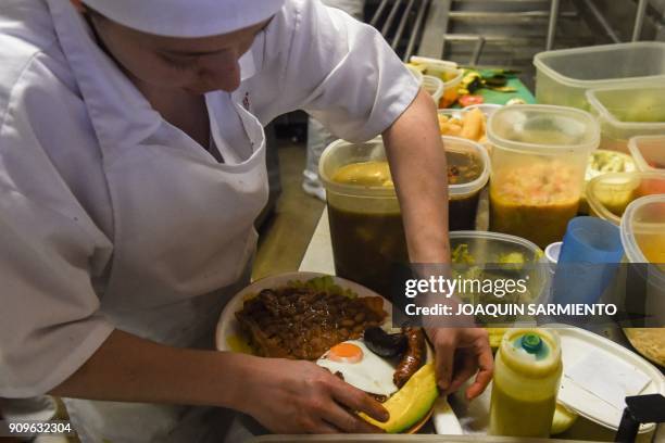 Woman chef prepares a "Bandeja Paisa" at a restaurant in Medellin, Antioquia department, on January 22, 2018. T - The "Bandeja Paisa" is a...