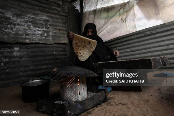 Palestinian mother bakes bread in the Rafah refugee camp in the southern Gaza Strip on January 24, 2018. The head of the United Nations agency for...