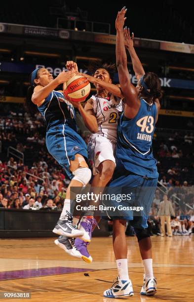 Cappie Pondexter of the Phoenix Mercury takes the ball to the basket against Lindsey Harding and Nakia Sanford of the Washington Mystics during the...