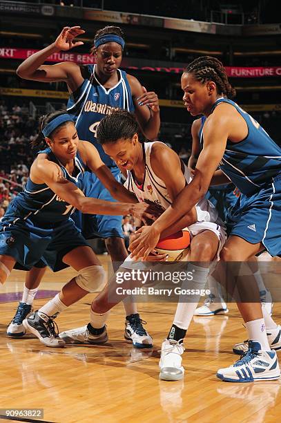 DeWanna Bonner of the Phoenix Mercury fights for possesion against Lindsey Harding, Monique Currie and Nakia Sanford of the Washington Mystics during...