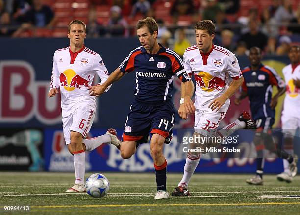 Steve Ralston of the New England Revolution plays the ball against Luke Sassano and Seth Stammler of the New York Red Bulls at Giants Stadium in the...