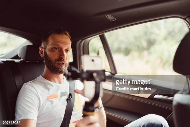 man vlogging in taxi - documentaire stockfoto's en -beelden