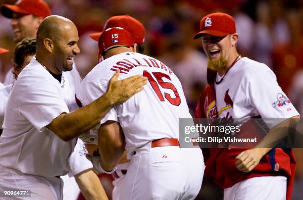 Albert Pujols and Ryan Frankilin of the St. Louis Cardinals congratulate teammate Matt Holliday after Holliday hit a walk-off solo home run against...