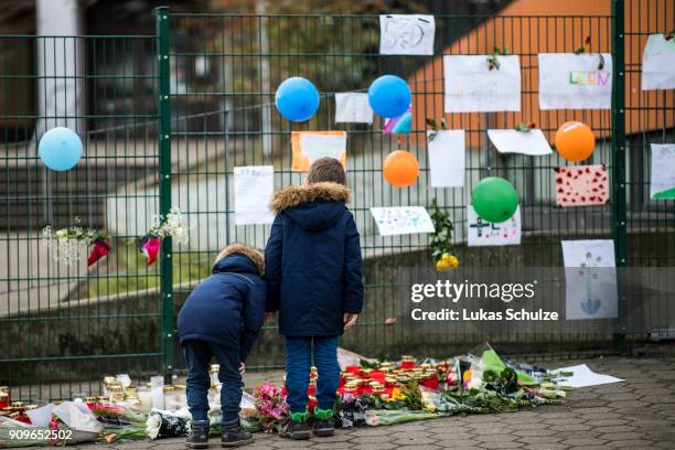 Children look at floral tributes at Kaethe Kollwitz comprehensive school following the stabbing of a pupil one day before on January 24, 2018 in...