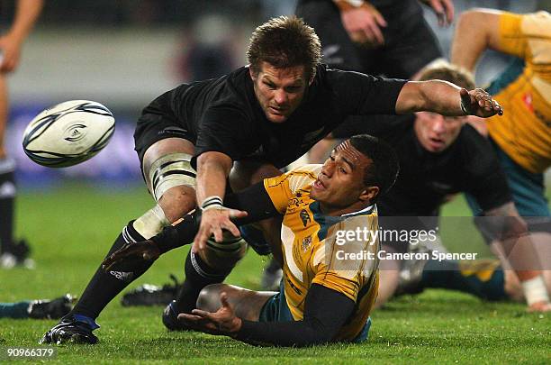 Will Genia of the Wallabies offloads the ball as he is tackled by All Blacks captain Richie McCaw during the 2009 Tri Nations series Bledisloe Cup...