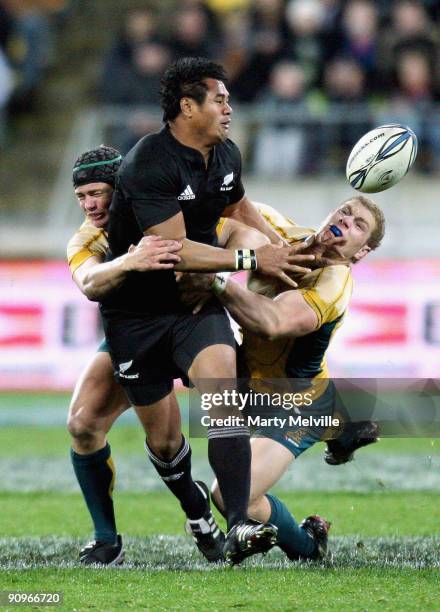 Isaia Toeva of the All Blacks is tackled by Berrick Barnes and David Pocock of the Wallabies during the 2009 Tri Nations series Bledisloe Cup match...