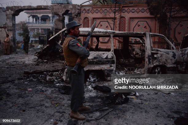 Afghan security forces inspect the site of attack on British charity Save the Children office in Jalalabad on January 24, 2018. Save the Children...