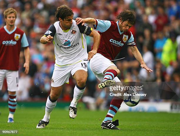Graham Alexander of Burnley holds off a challenge from Lorik Cana of Sunderland during the Barclays Premier League match between Burnley and...