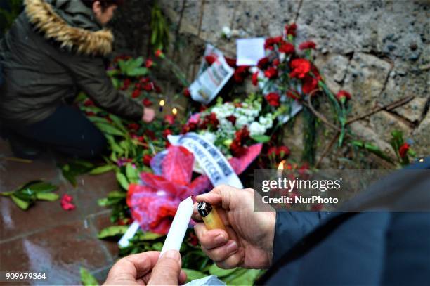 Person lights up a candle as people gather on the spot, where Turkish journalist Ugur Mumcu was assassinated, during a commemoration to mark the 25th...