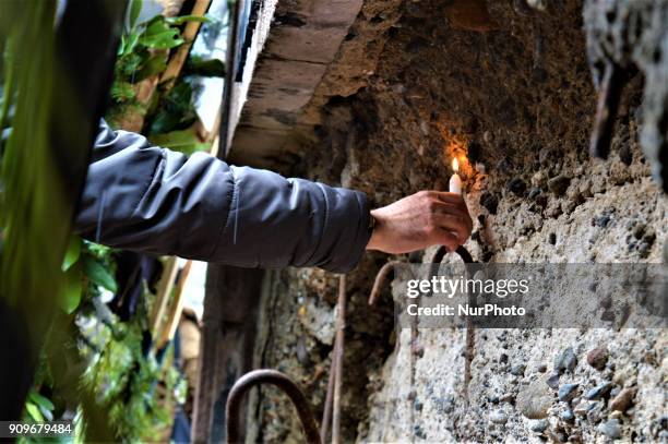 Man lays a candle next to the wall of a monument as people gather on the spot, where Turkish journalist Ugur Mumcu was assassinated, during a...