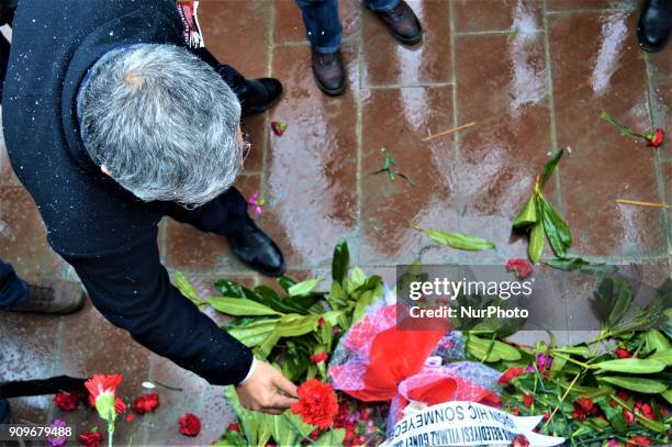 Man lays a flower as people gather on the spot, where Turkish journalist Ugur Mumcu was assassinated, during a commemoration to mark the 25th...
