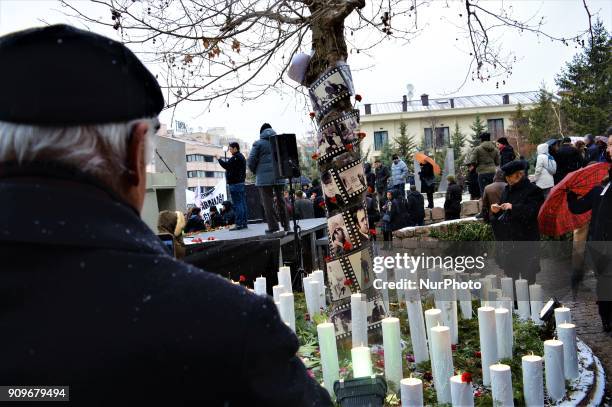Man looks at a tree covered with candles and portraits as people gather on the spot, where Turkish journalist Ugur Mumcu was assassinated, during a...