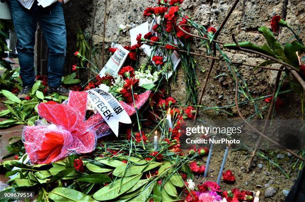 Flowers are placed next to the wall of a monument as people gather on the spot, where Turkish journalist Ugur Mumcu was assassinated, during a...