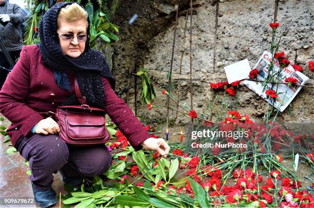 Woman lays a flower as people gather on the spot, where Turkish journalist Ugur Mumcu was assassinated, during a commemoration to mark the 25th...