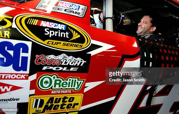 Tony Stewart sits aboard the Old Spice/Office Depot Chevrolet prior to practice for the NASCAR Sprint Cup Series Sylvania 300 at the New Hampshire...