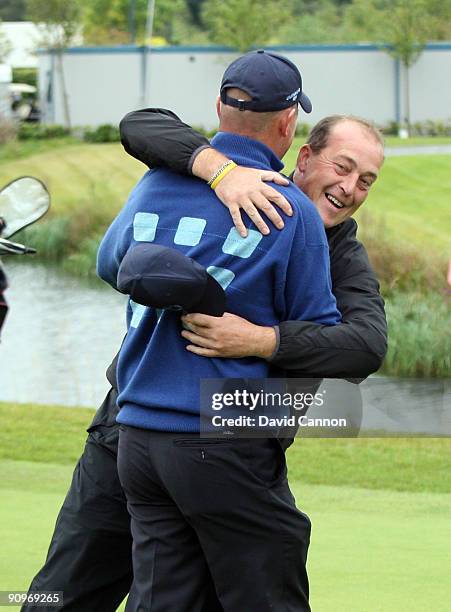 Andrew Barnett of Wales and the Great Britain and Ireland Team is congratulated by Jon Bevan at the 18th hole after Barnett and James Lee had won...