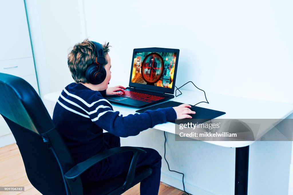 Boy Sits Front Of Computer And Plays A Video Game High-Res Stock Photo ...