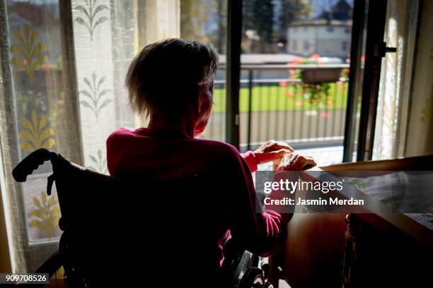 disabled senior woman in wheelchair at home in living room - alzheimers stock pictures, royalty-free photos & images