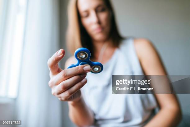 close-up of spinner held by woman - fidget spinner stock-fotos und bilder