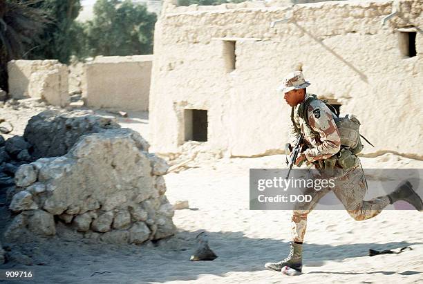 Soldier runs for cover as he takes part in an urban warfare training exercise being staged in an abandoned town during Operation Desert Shield.