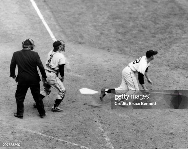 Don Mueller of the New York Giants hits a homerun as catcher Clyde McCullough of the Pittsburgh Pirates and umpire Dusty Boggess look on during an...