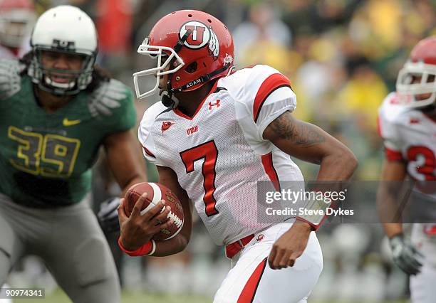 Quarterback Terrance Cain of the Utah Utes runs for yardage as Will Tukuafu defends in the first quarter of the game at Autzen Stadium on September...