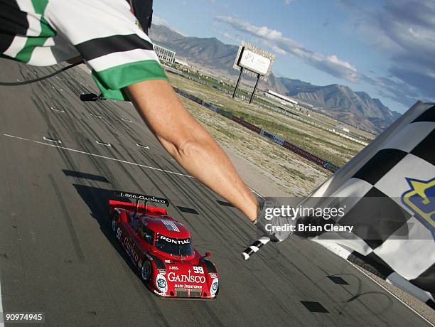 The Pontiac Riley of Alex Gurney and Jon Fogarty takes the checkered flag to win the Utah 250 at Miller Motorsports Park on September 19, 2009 in...