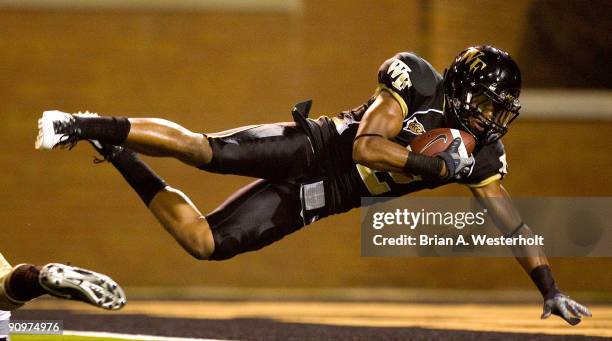 Wide receiver Chris Givens of the Wake Forest Demon Deacons falls into the end zone after catching a 54 yard touchdown pass in the second quarter of...