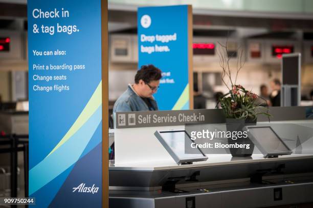 Traveler uses an Alaska Air Group Inc. Self check-in kiosk at the San Francisco International Airport in San Francisco, California, U.S., on Friday,...