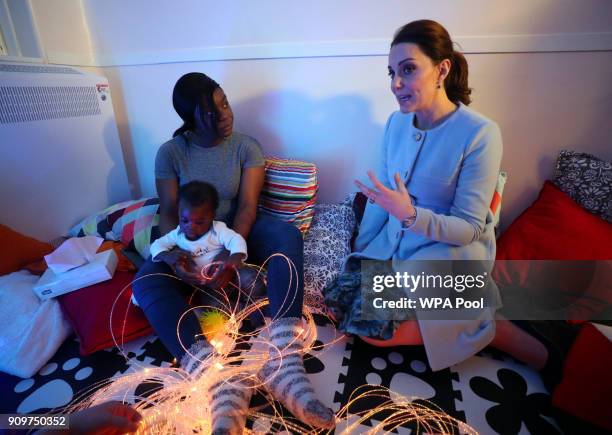Catherine, Duchess of Cambridge speaks to patient Esther and her son Nehemiah, during a visit to the sensory room at the Mother and Baby unit at the...