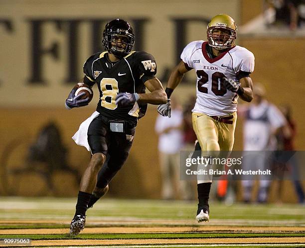 Marshall Williams of the Wake Forest Demon Deacons breaks away from Cameron McGlenn of the Elon Phoenix for an 80-yard touchdown during third quarter...