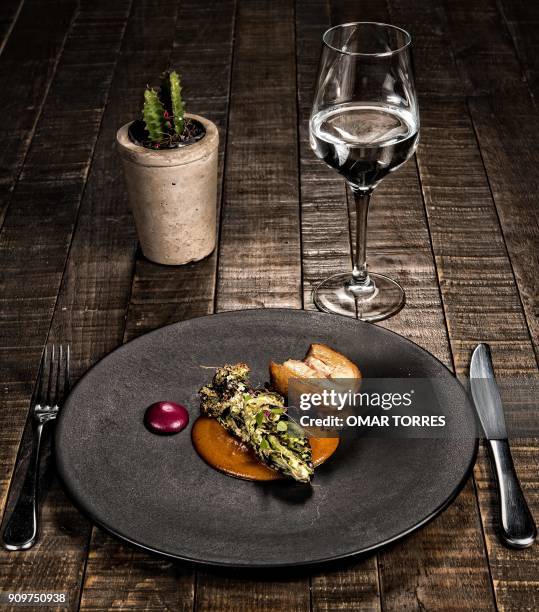 Dish called "Lechon Confitado" with "Xanducata" and purple carrot, is pictured at Mexican chef Fernando Martinez's restaurant "Seneri" -which...