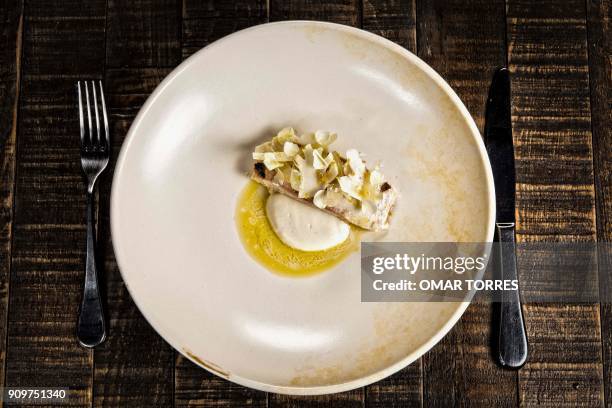 Dish of white fish poached in olive oil with creamy rice, Cotija cheese and cauliflower is pictured at Mexican chef Fernando Martinez's restaurant...