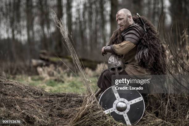 sword wielding bloody viking warrior alone in a winter forest - traditional armor stock pictures, royalty-free photos & images