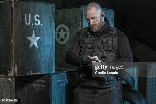 military krav maga fighting group member of swat team posing in dark indoor urban setting - shaved head stock pictures, royalty-free photos & images