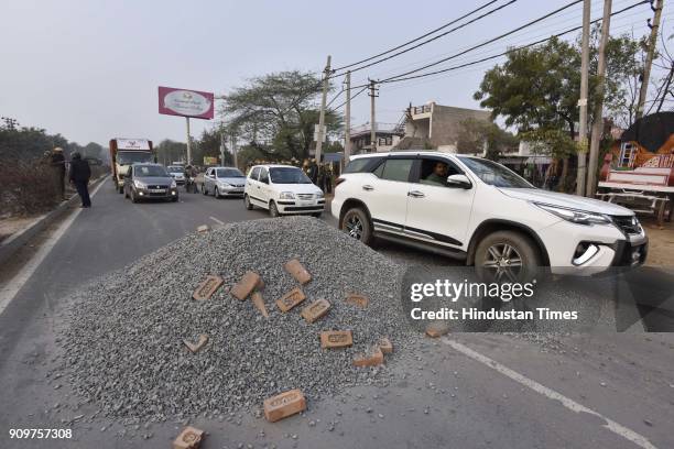 The pile of gravel dumped on road in order to block the traffic near village Bhondsi in Gurgaon allegedly by activists of Karni Sena, who were...