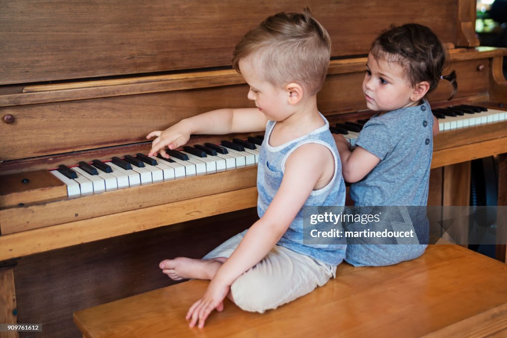 かわいい子供たちは、家でピアノを演奏ましょう。