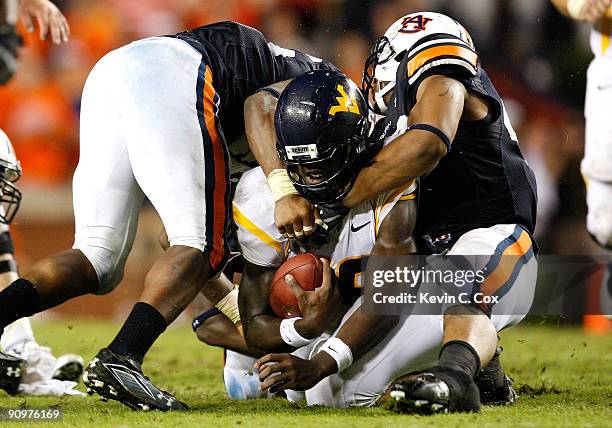 Craig Stevens and Michael Goggans of the Auburn Tigers tackle quarterback Jarrett Brown of the West Virginia Mountaineers at Jordan-Hare Stadium on...