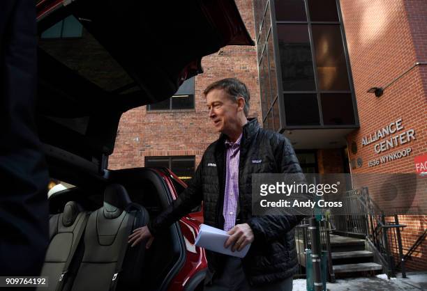 Colorado Governor John Hickenlooper checks out the back seats underneath the Falcon Wing doors of a Tesla Model X electric car before his press...
