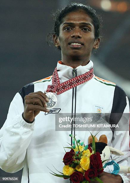 In this file photo taken December 9 India's Santhi Soundarajan holds her silver medal on the winner's podium after the women's 800m final on the...