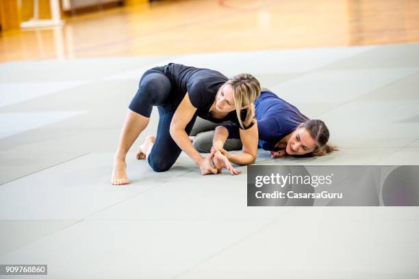 young adult women at selfdefence course with judo trainer - judo woman stock pictures, royalty-free photos & images