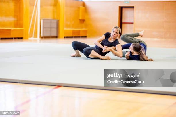 jonge volwassen vrouwen op selfdefence cursus met judo trainer - vechtsport stockfoto's en -beelden
