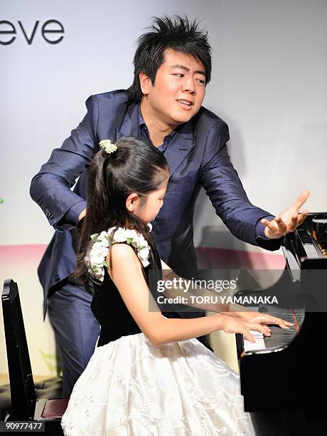 Chinese pianist Lang Lang instructs nine-year-old Shion Ota during a music event for Japanese children in Tokyo on September 20, 2009. Lang is in...