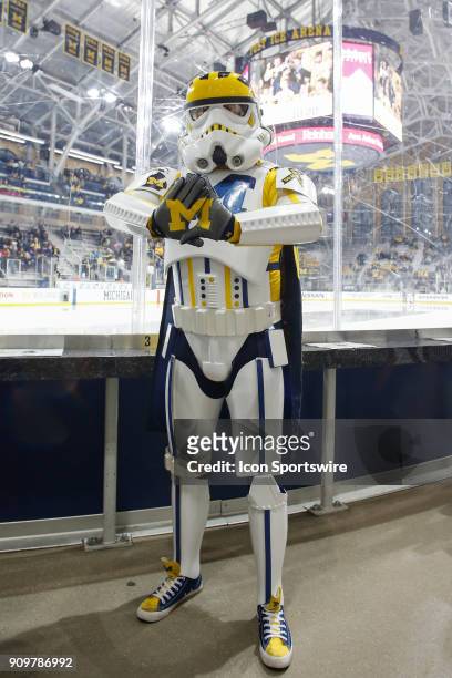 Fan dressed in a Michigan-themed Star Wars Stormtropper costume poses for photographs during a regular season Big 10 Conference hockey game between...