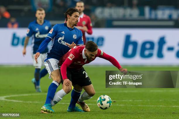 Benjamin Stambouli of Schalke and Kenan Karaman of Hannover battle for the ball during the Bundesliga match between FC Schalke 04 and Hannover 96 at...