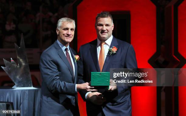 Flyers President Paul Holmgren presents a gift to Eric Lindros during his Jersey Retirement Night ceremony, prior to a NHL game between the...