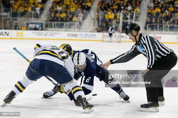 Michigan Wolverines forward Cooper Marody and Penn State Nittany Lions forward Chase Berger battle for control of the puck during a face-off during a...