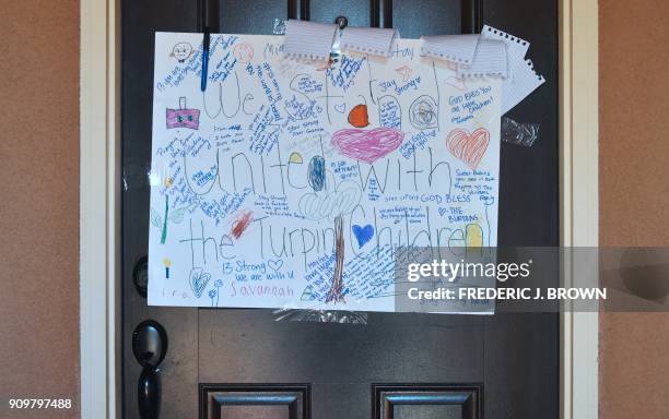 Personal handwritten notes are seen on a piece of paper hanging on the front door of the Turpin family's home in Perris, California on January 24...