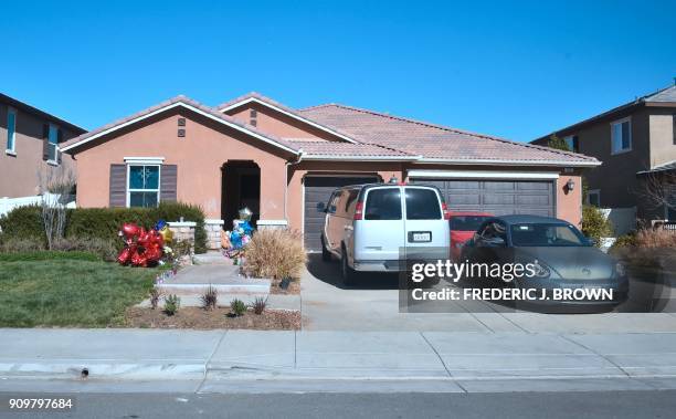 Balloons, flowers and other momentos are seen in front of the Turpin family's home in Perris, California on January 24 ahead of another court hearing...